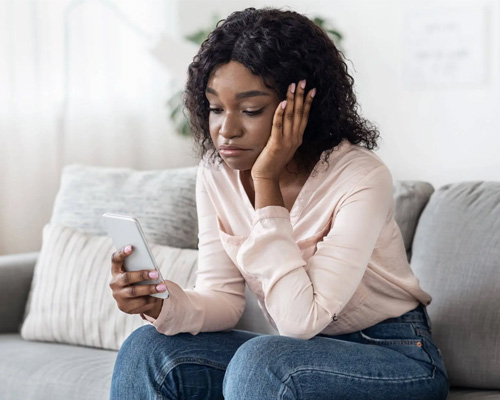 A young woman anxiously awaiting a reply in a SMS conversation from significant other. - Addiction and codependency concept image